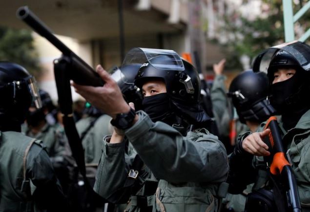 شرطي يصوب سلاحه خلال احتجاج مناهض للحكومة في الصين. تصوير: أحمد مسعود - رويترز